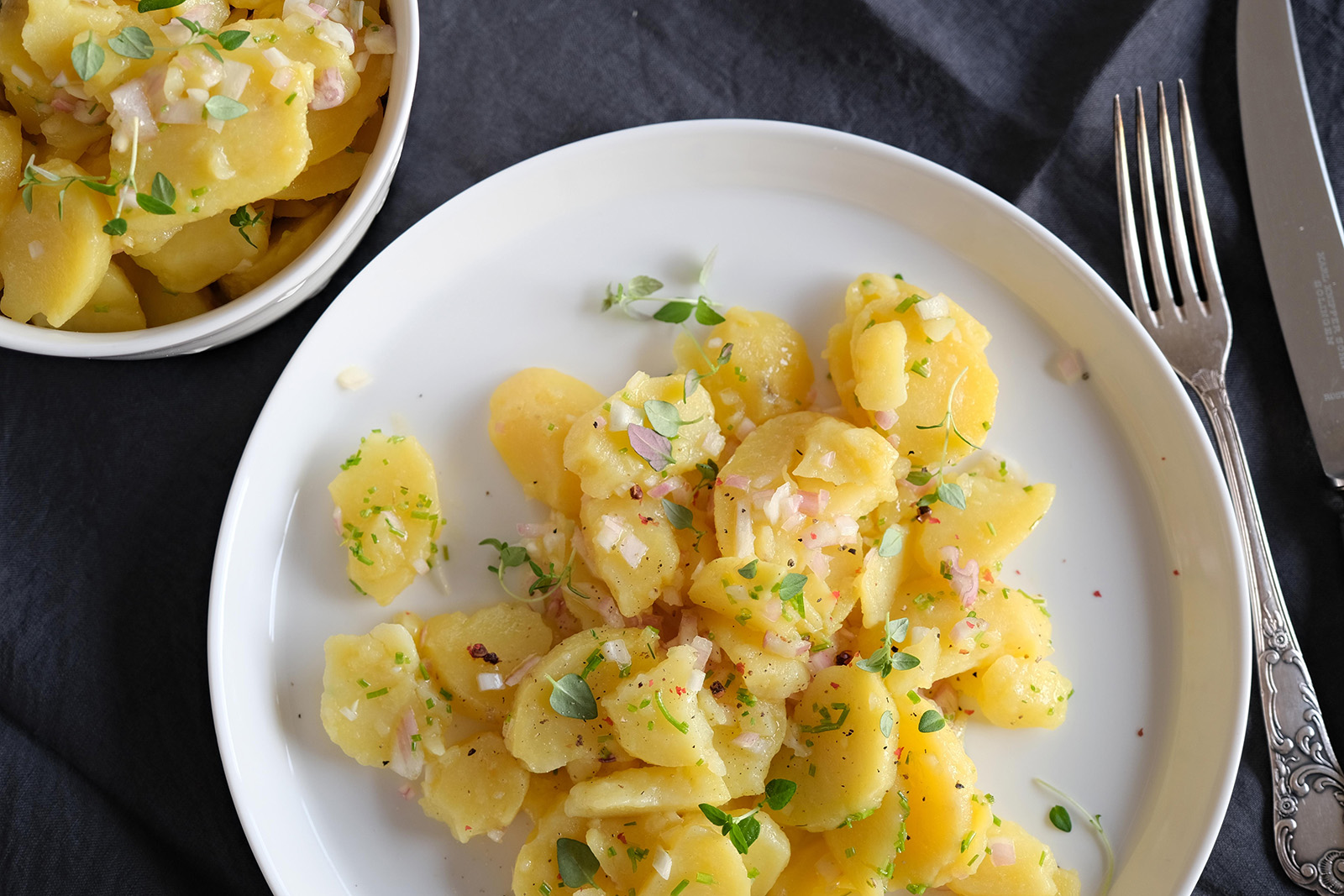 Klasický bramborový salát je bez majonézy, jen zalitý teplým dresinkem z vývaru a octa.